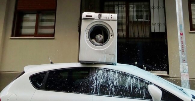 Apartmanın önüne park edilen aracın üzerine çamaşır makinesi attı